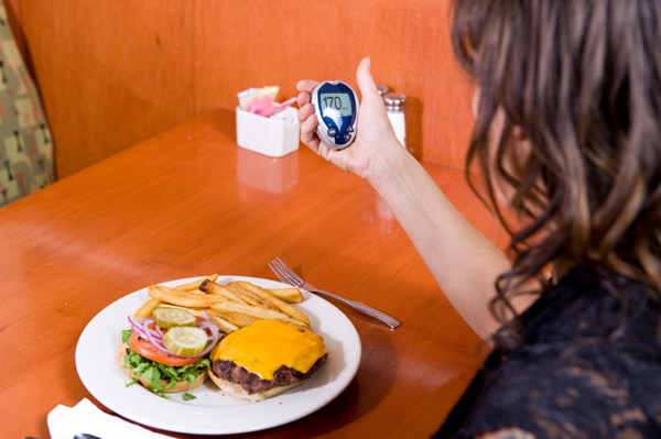 Woman checking blood sugar before meal