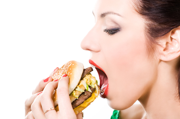 fat man eating burger. and she eats like a man.