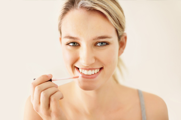 Woman applying lip gloss