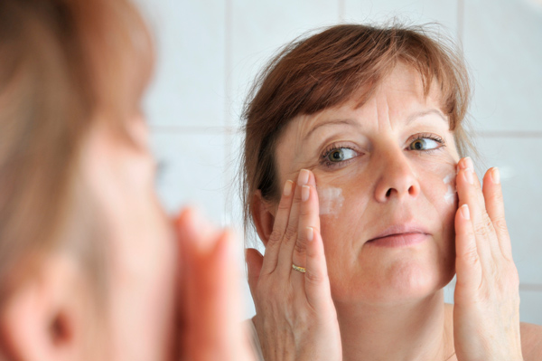Woman exfoliating face