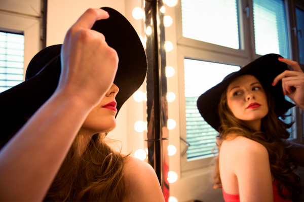 Woman with frizzy hair trying on hat