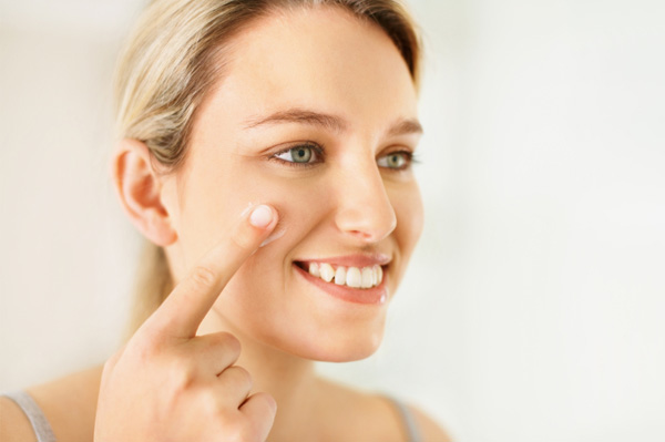 Redness On Face. Woman moisturizing face