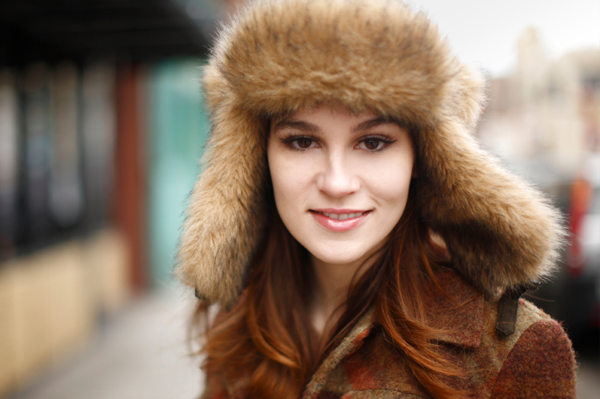Woman with beautiful skin in a winter trapper hat