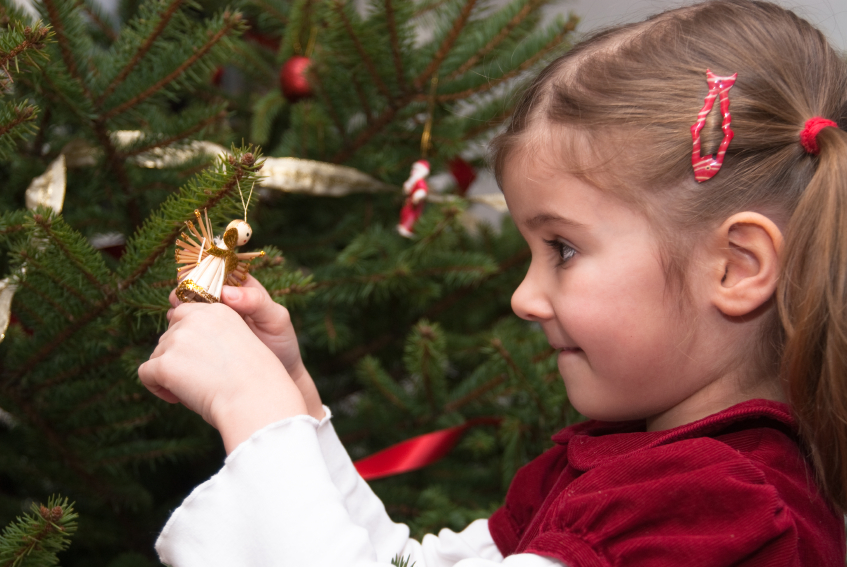 Young girl decorating a Christams tree