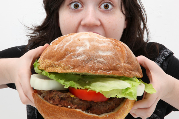 fat man eating burger. Woman eating giant urger