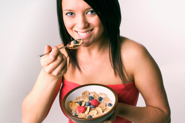 Woman eating cereal with fruit