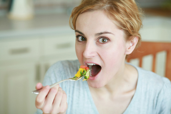 Woman eating vegetables