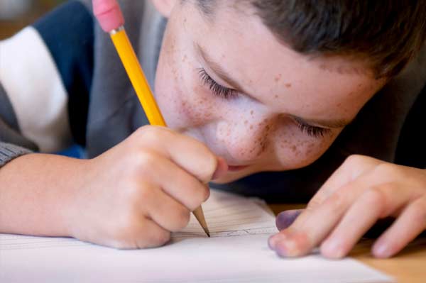boy writing with pencil
