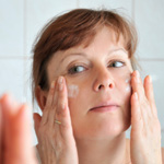 Woman putting on anti-aging moisturizer