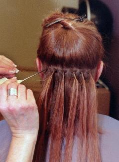 Woman getting hair extensions at the salon