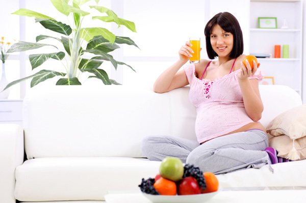 Pregnant woman eating oranges