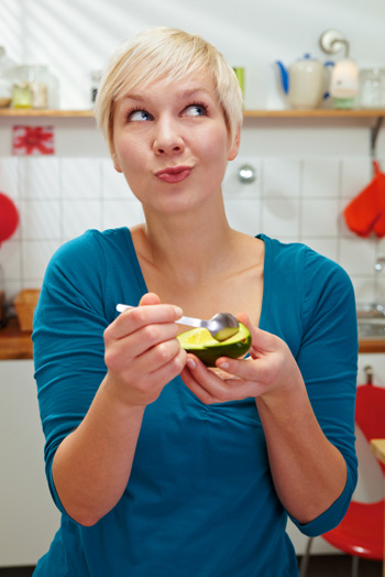 Woman eating avocado