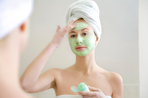 Woman applying facial mask