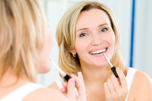 Woman applying lip gloss
