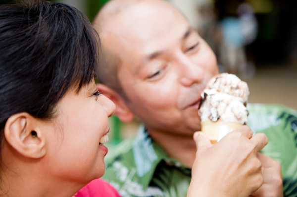 Couple sharing ice cream cone without the kids