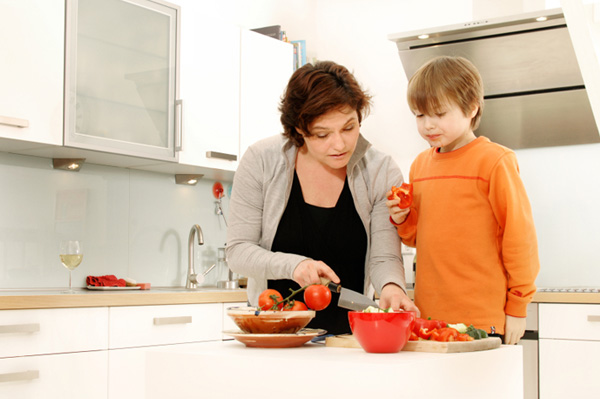 Mom chopping veggies with son