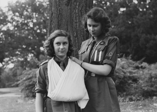 Princess Elizabeth places Princess Margaret's arm in a sling