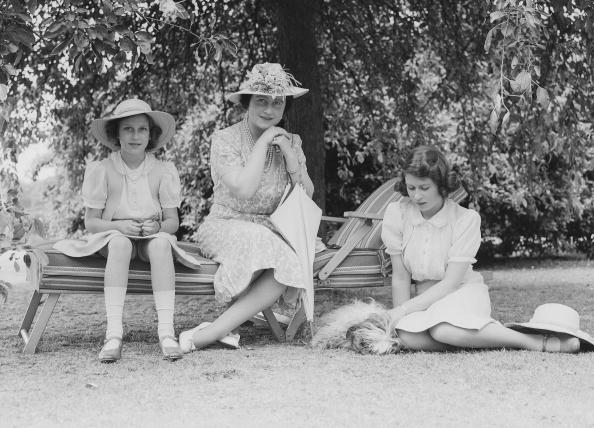The Queen Mother (1900-2002). Princess Elizabeth and Princess Margaret sitting in the garden at Windsor Castle, England on July 8, 1941