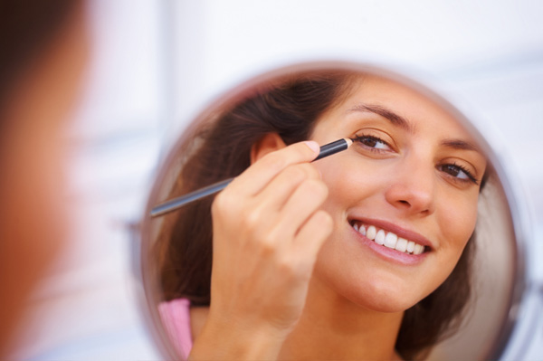 Woman applying eye liner