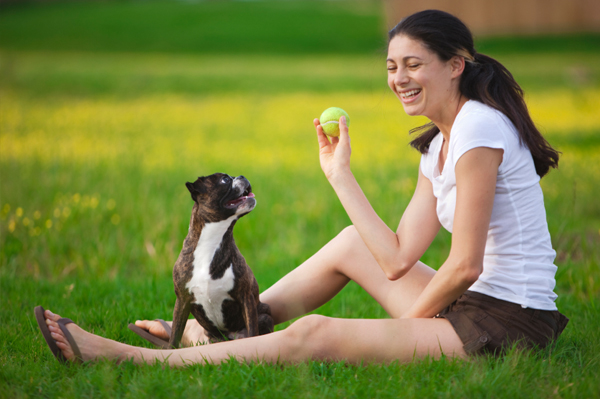 Woman playing ball with dog