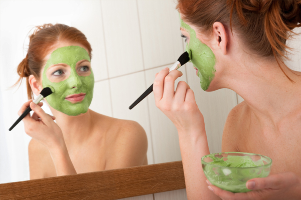 Woman putting on green face mask