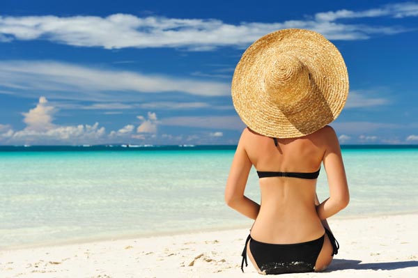 Fashionable woman sitting on the beach