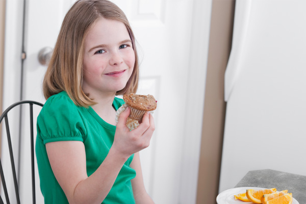 Girl eating pumpkin spice muffin