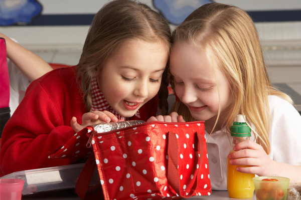Girls peaking into lunchbox