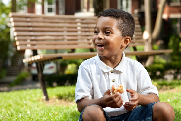 Little boy eating sandwich on the go