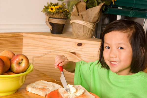 Little girl making toast