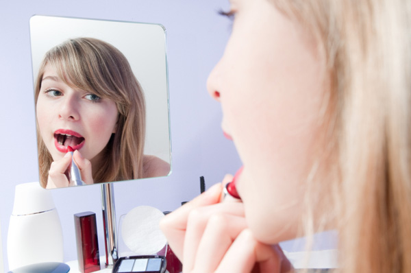Woman applying lipstick