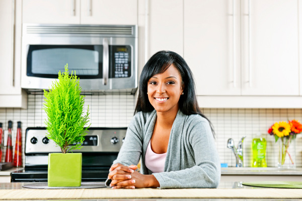 Woman in kitchen with houseplant