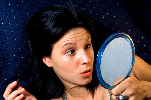 Woman plucking eyebrow