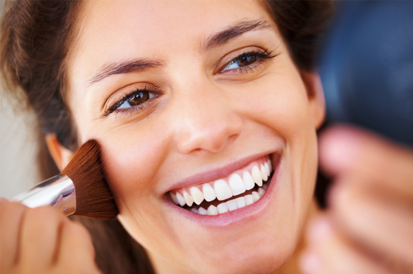 Woman putting on blush