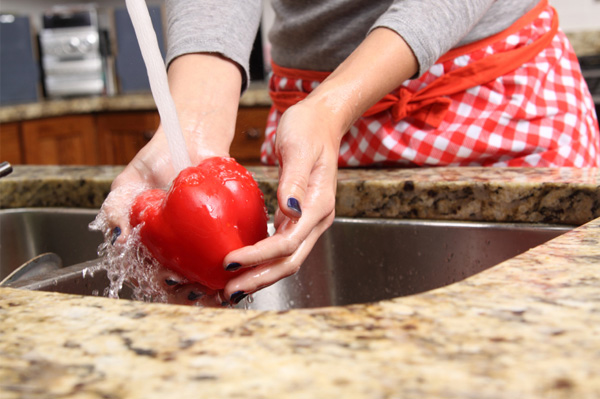 Woman washing red peppers