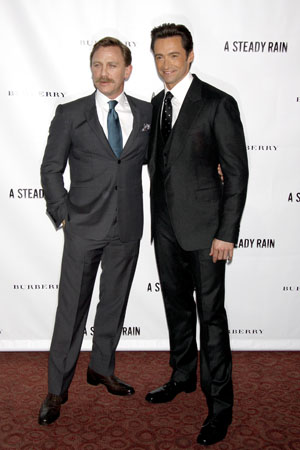 Daniel Craig with a mustache, next to Hugh Jackman