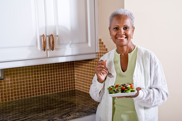 Elderly woman eating salad