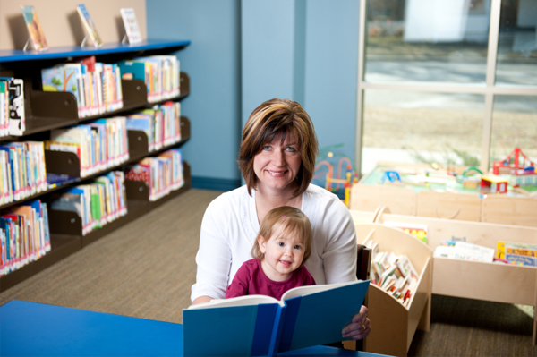 Mom reading to toddler at library