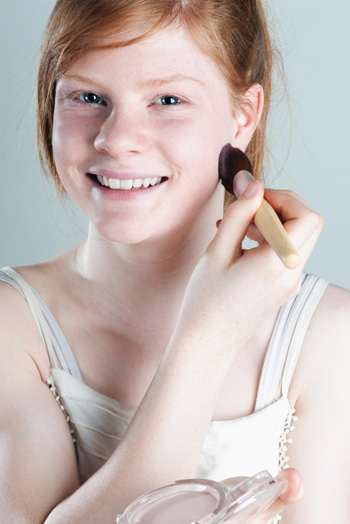Girl applying powder foundation