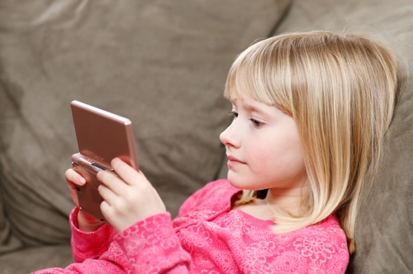 Little girl playing with handheld video game