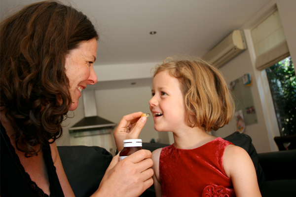 Mom giving daughter vitamin