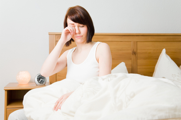 Tired woman rubbing eyes