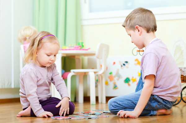 Brother and sister playing with a puzzle