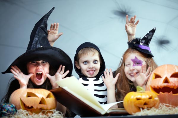 Costumed kids reading a Halloween book