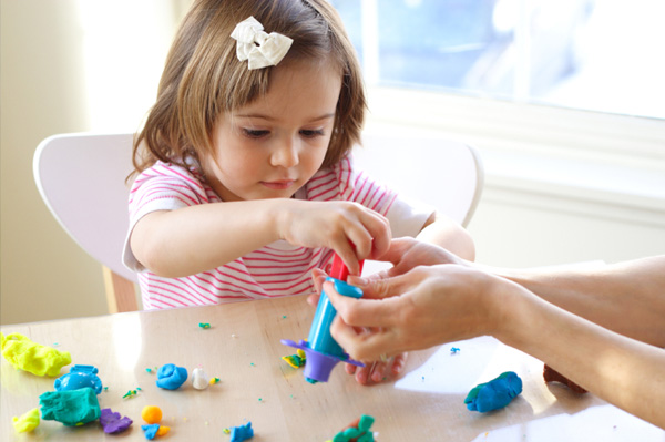 Little girl playing with clay