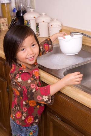 Little girl washing dishes