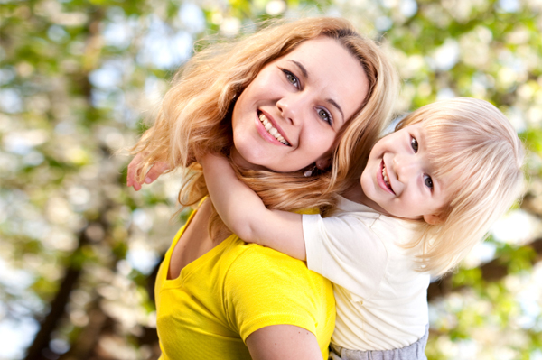 Mom giving preschooler piggyback ride