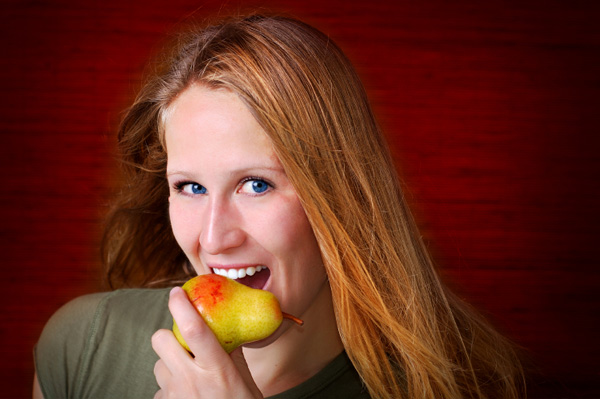 Woman eating pear as a snack