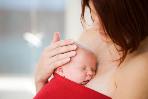 Mother with newborn wearing red