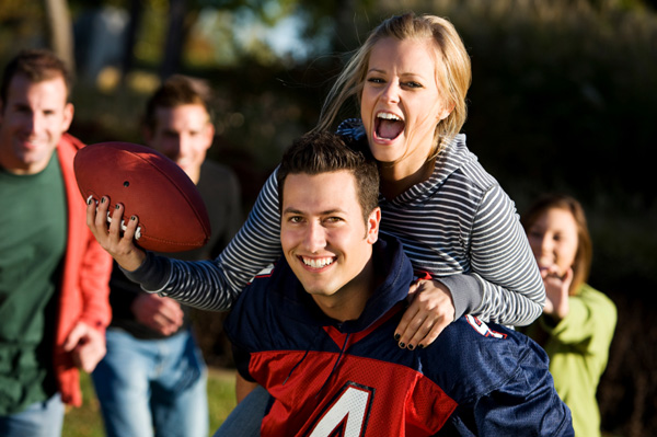 Couple playing football with friends